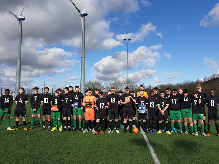 Learners stand together on the astro-turf pitch following their football match which aimed to raise awareness on mental health.