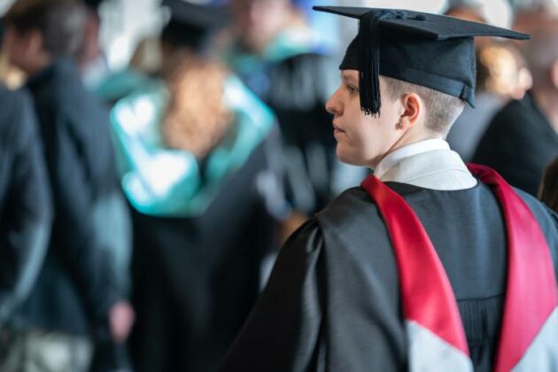 A student looking away at the stage at one of our Higher Education Graduation ceremonies.