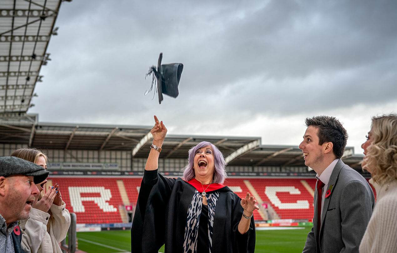 A student throwing up their cap after the graduation ceremony