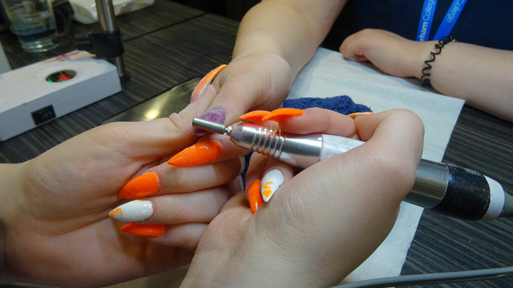 A student giving a client a nail treatment