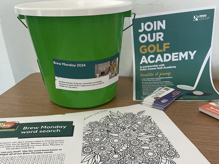 A bucket next to a Join Our Golf Academy poster