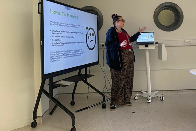 Someone stood in front of a TV screen speaking about anti bullying week