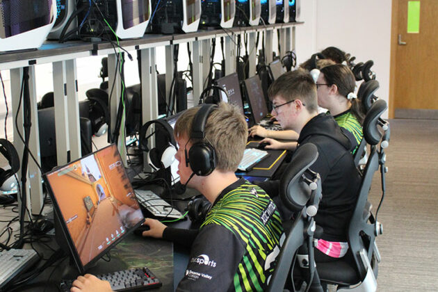 An esports students sat in front of a computer