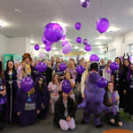 A group of staff and students all wearing purple raising money for Weston Park Cancer Charity