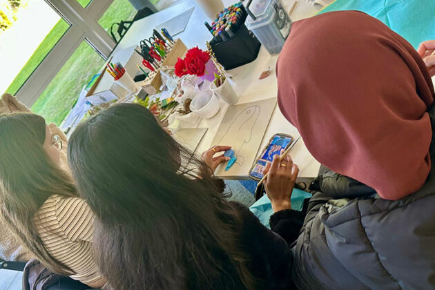 Students sat at a table doing some sustainability artwork